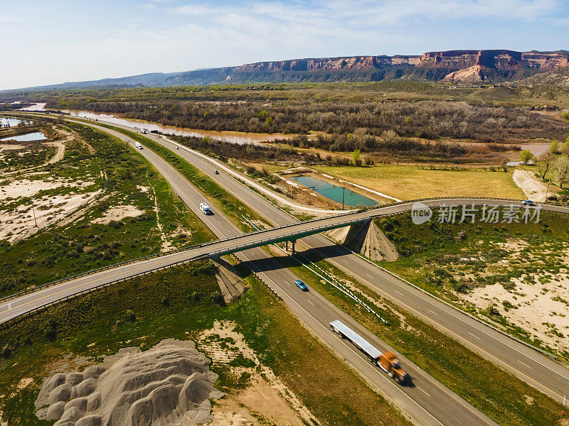 在美国西部70号州际公路和立交桥上行驶的车辆和半卡车的橙色平板半卡车无人机视图Fruita Colorado照片系列